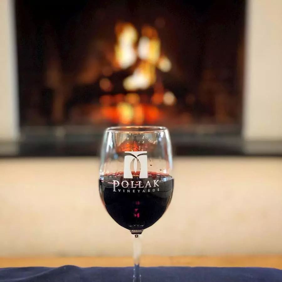 Glass of red wine by the fire