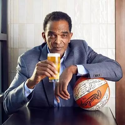 Founder holding a basketball and beer from Ralph Sampson's American Taproom.